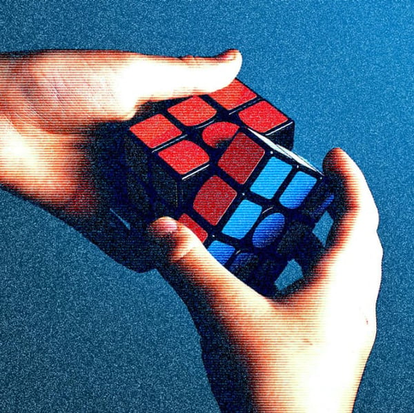 Two hands manipulate a Rubik's Cube.