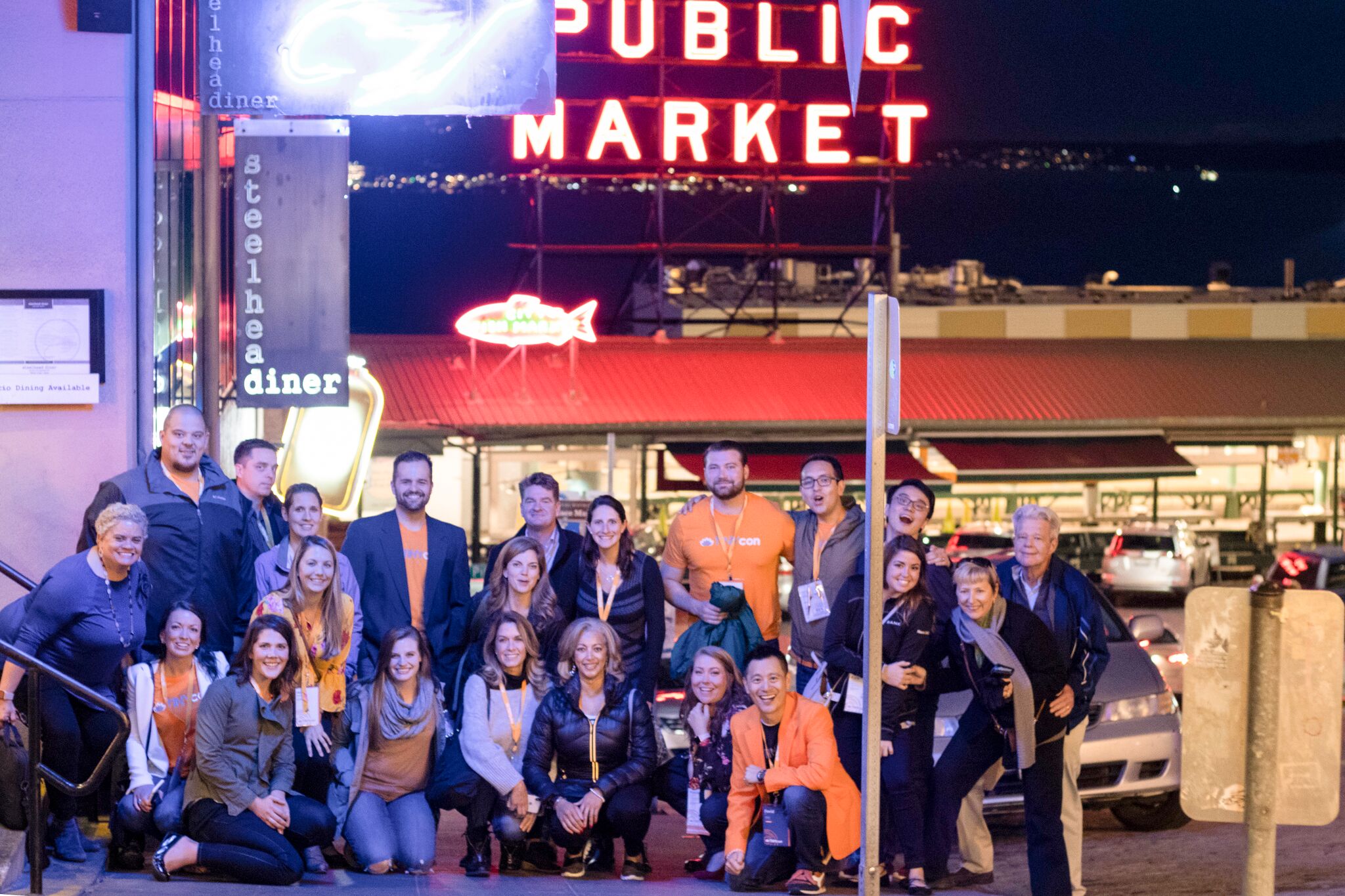 A group of TINYpulsers and attendees pose for a photo-op in front of pike place market