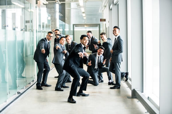 men in suits all looking happy in hallway
